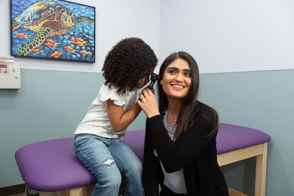 Dr. Mariam Nasir getting ear exam from girl
