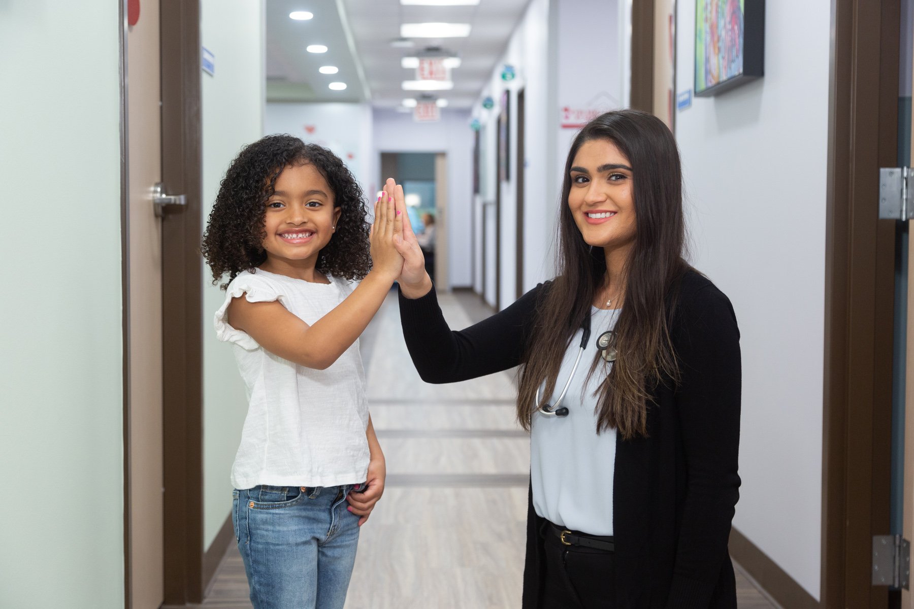 Dr. Mariam Nasir giving high five with girl