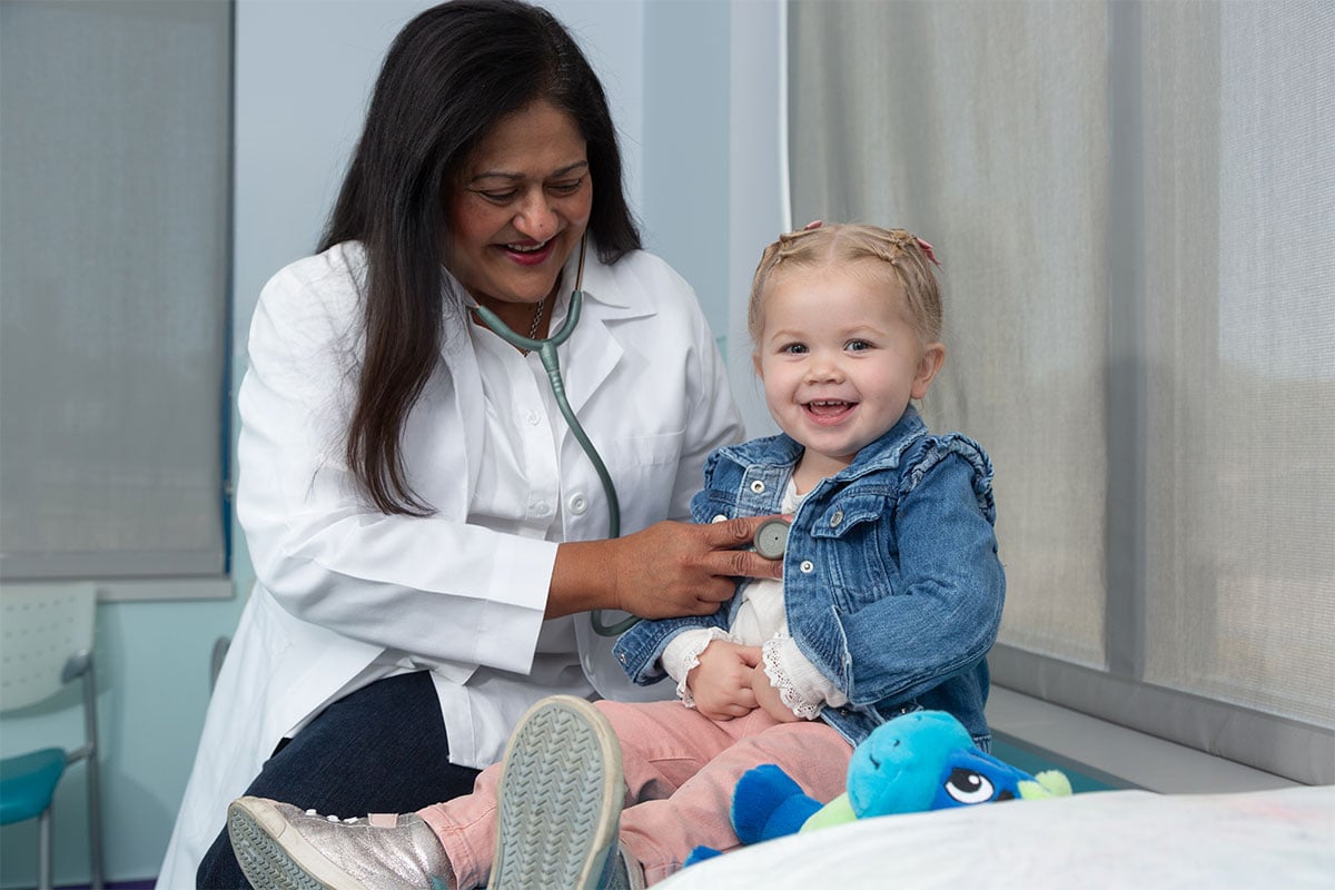 A pediatric physician examining a child at a primary care office in Ennis, Texas
