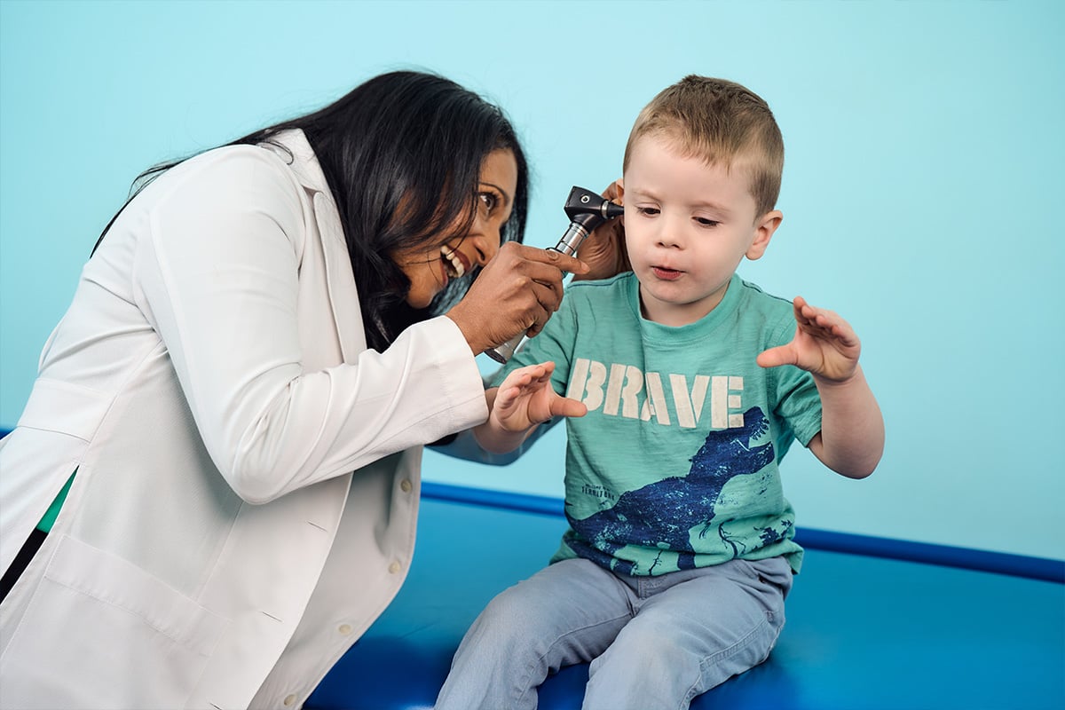 A pediatrician in Lewisville examining a young boys&rsquo; ears