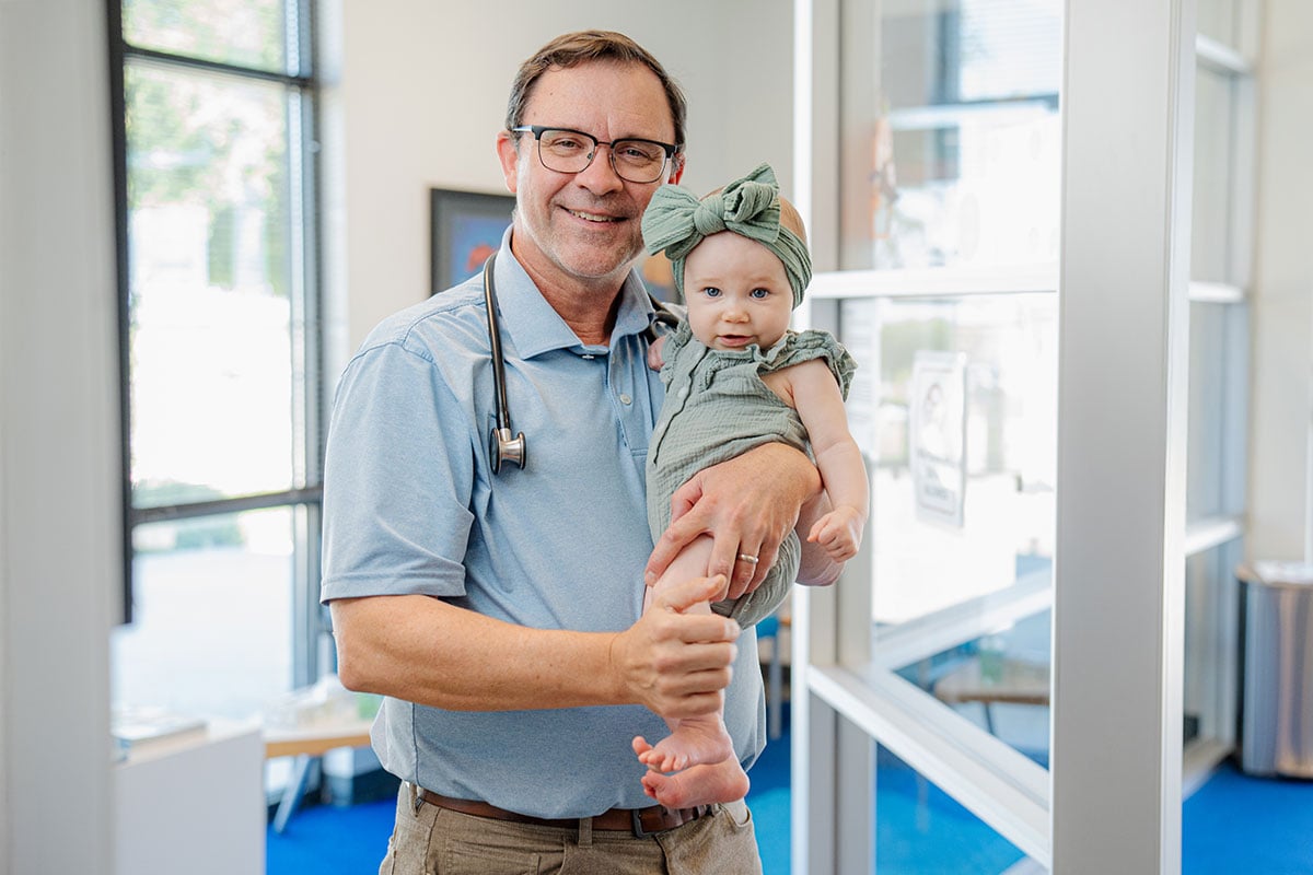 Primary care doctor smiling with a baby at a pediatric office in Little Elm, Texas