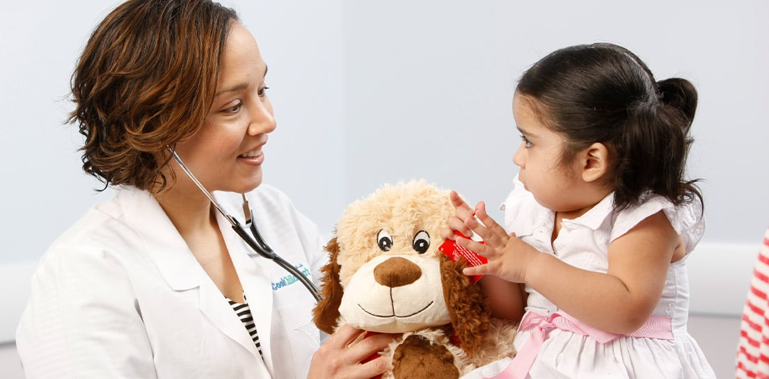 Dr. Evans holding teddy bear with patient