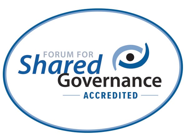 blue outlined oval with text Forum for Shared Governance Accredited inside with a small wavy icon that looks like an eye