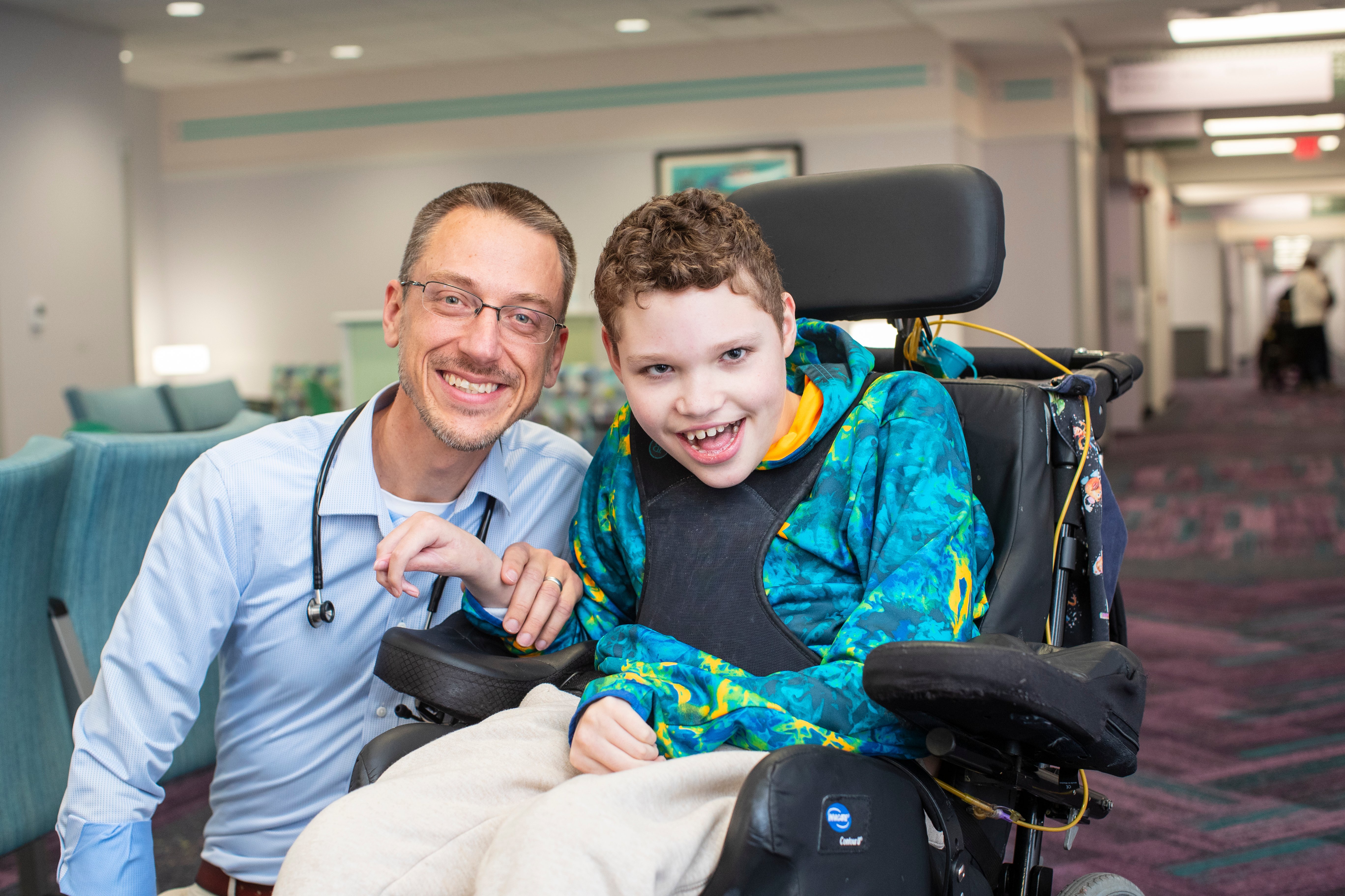 doctor with child in wheelchair smiling