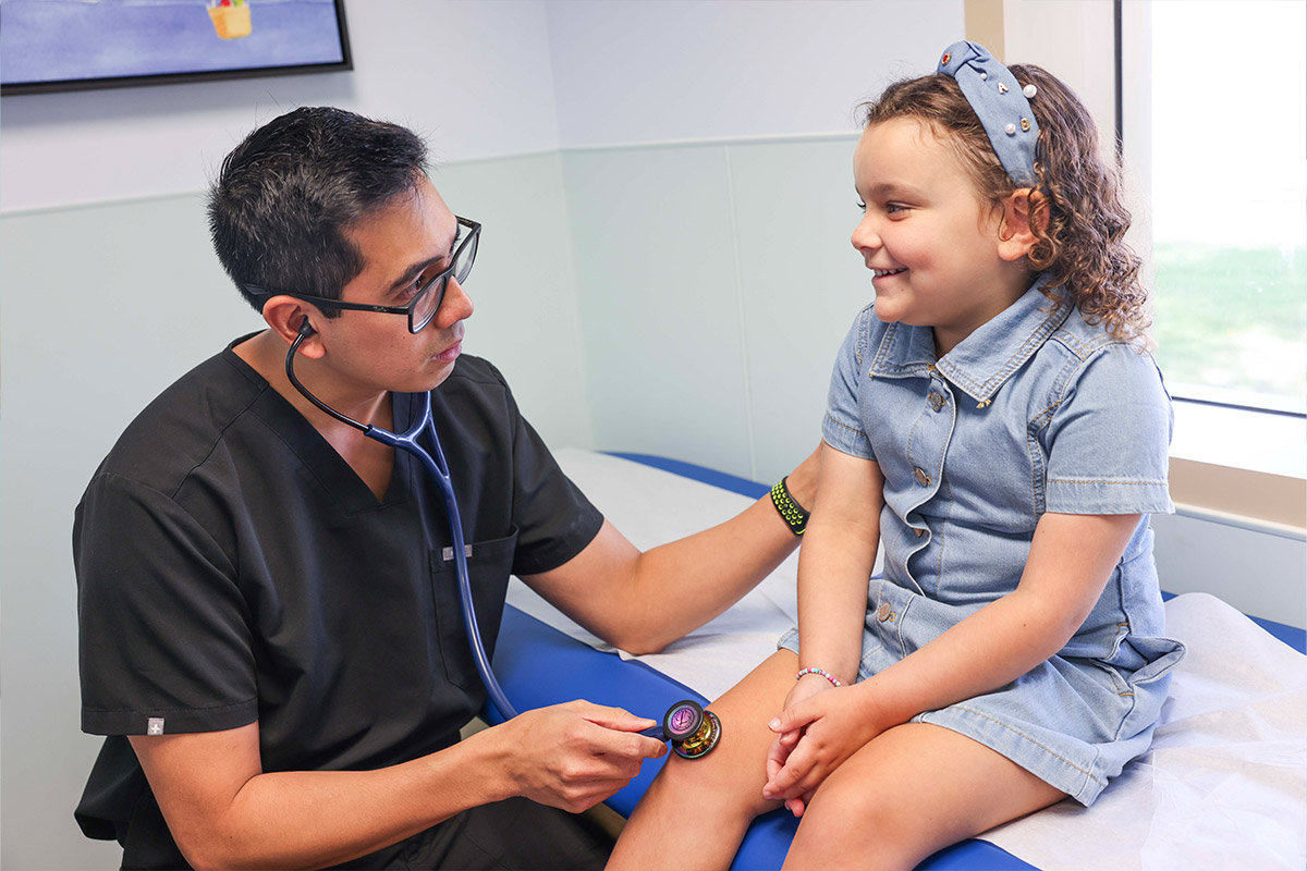 Doctor with stethoscope listening to girl