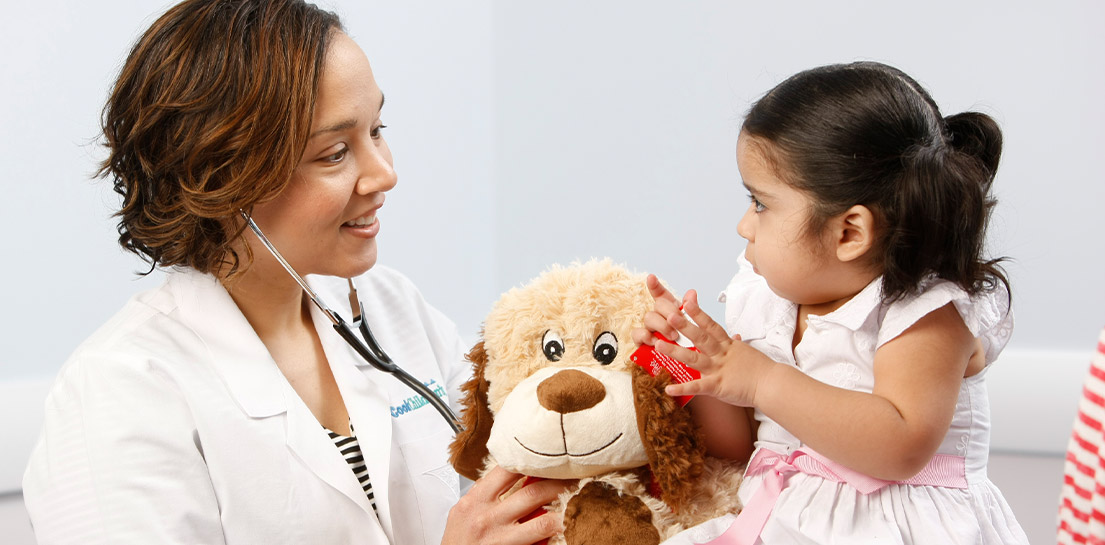 Dr. Evans holding teddy bear with patient Dr. Evans holding teddy bear with patient